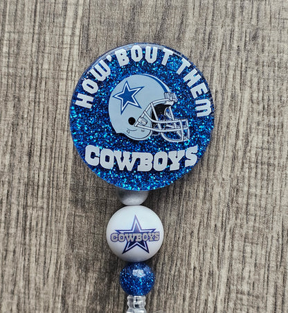 a badge reel displaying a cowboys helmet along with the words How about them Cowboys  around it