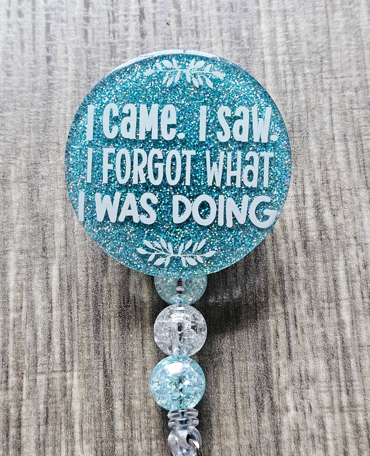 A badge reel featuring the phrase "I Came, I Saw, I Forgot What I Was Doing" in bold, humorous lettering.