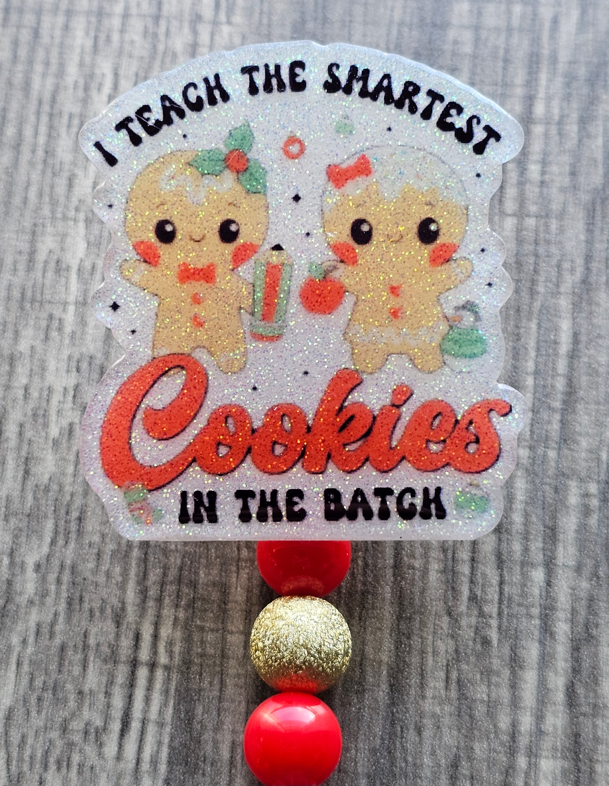 A badge reel stating I Teach the Smartest Cookies In the Batch While displaying two adorable gingerbread cookies with festive decor. 