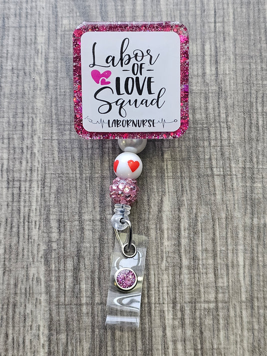 A Badge reel stating Labor Of Love Squad; labor nurse. with hearts, stethoscope and heartbeat pattern to show support for labor nurses .