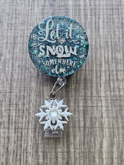 A badge reel stating let it snow somewhere else 