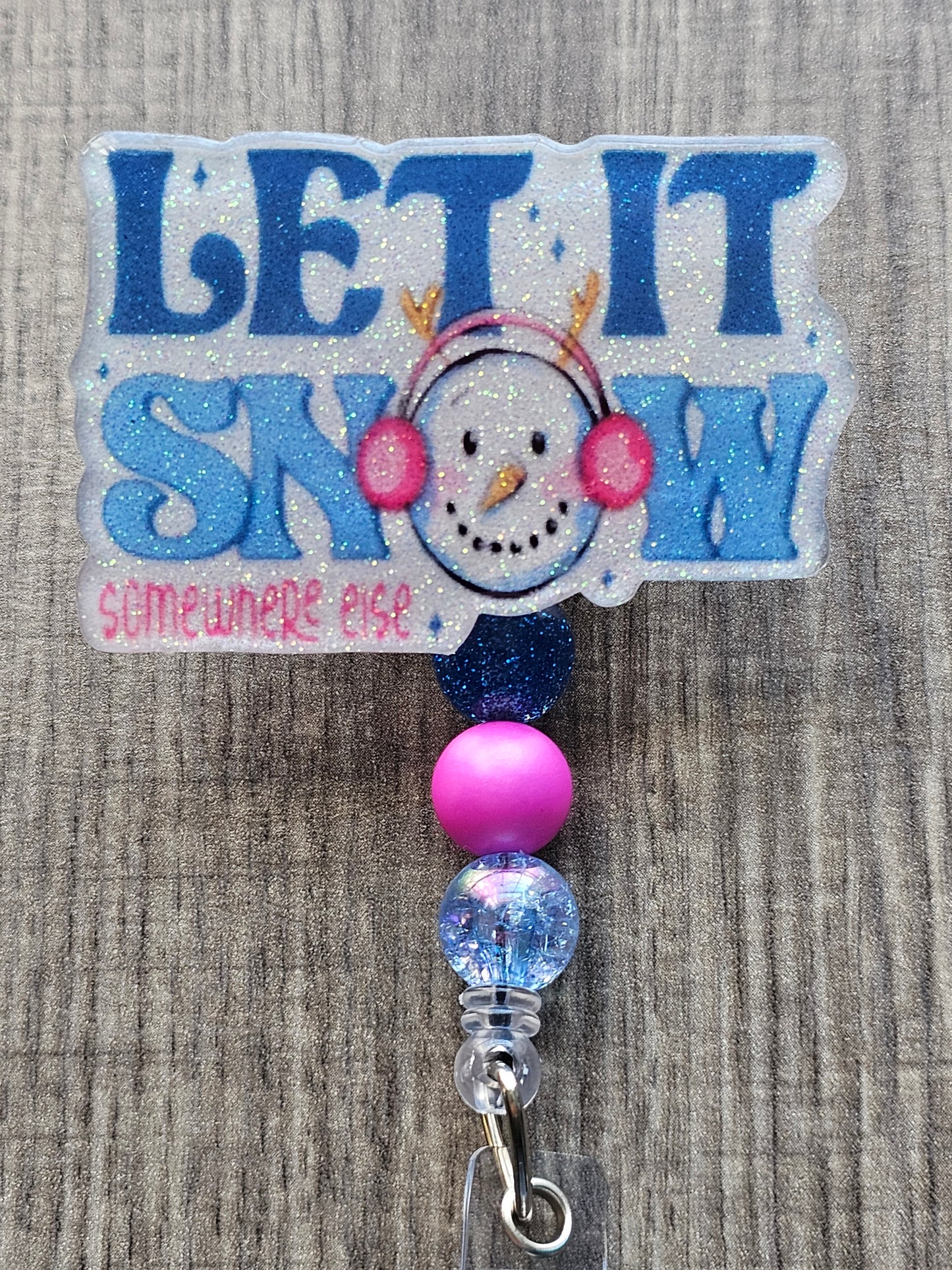 A badge reel stating Let it snow Somewhere Else