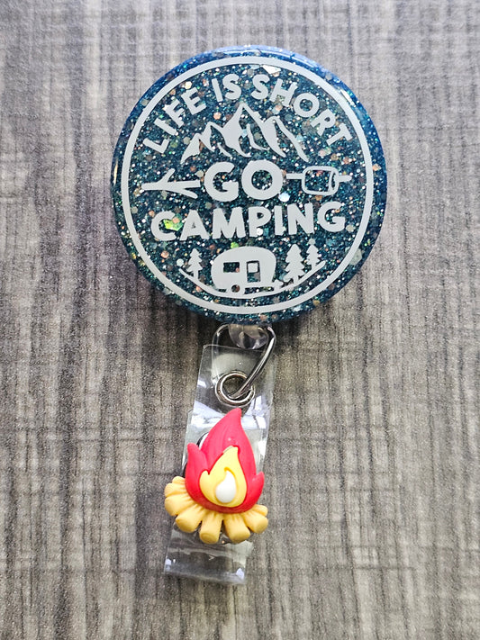  A Badge Reel featuring the statement life is short go camping with a peacock green background and camping décor