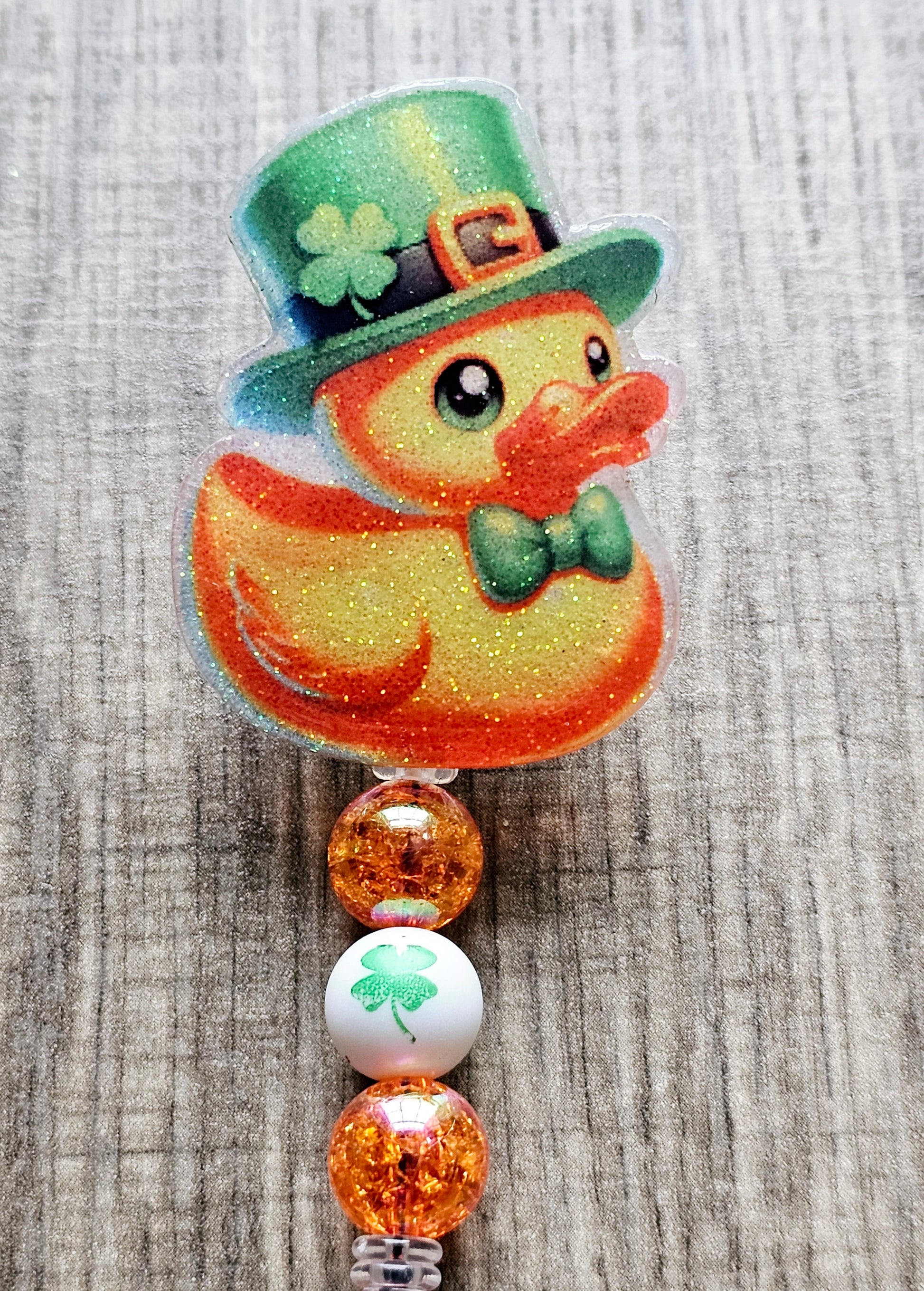 A badge reel featuring an adorable duck wearing a clover hat and bow tie in honor of St. Patrick’s Day.