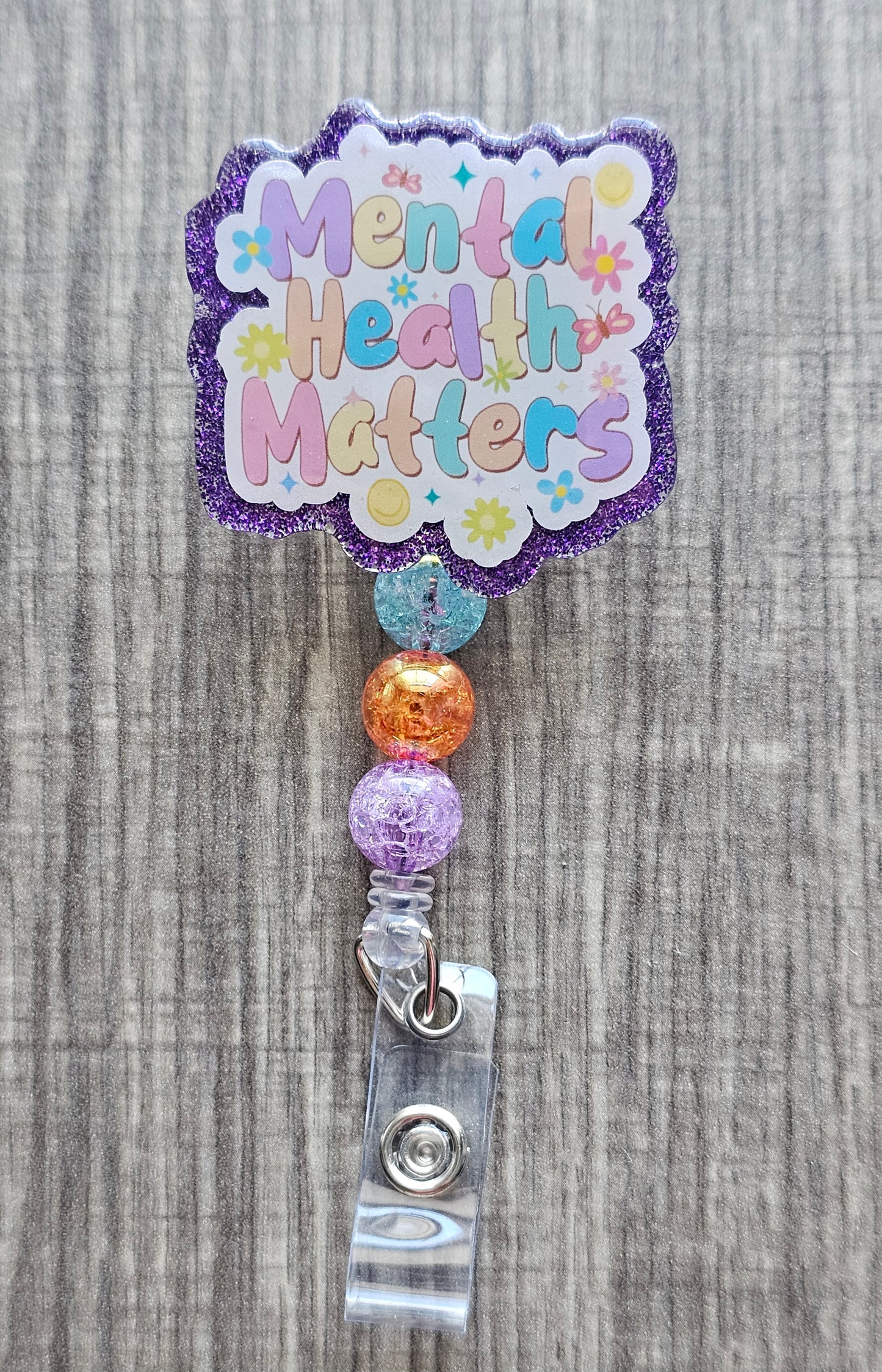 Mental Health Matters badge reel with flowers, butterflies, and smiles with beads.