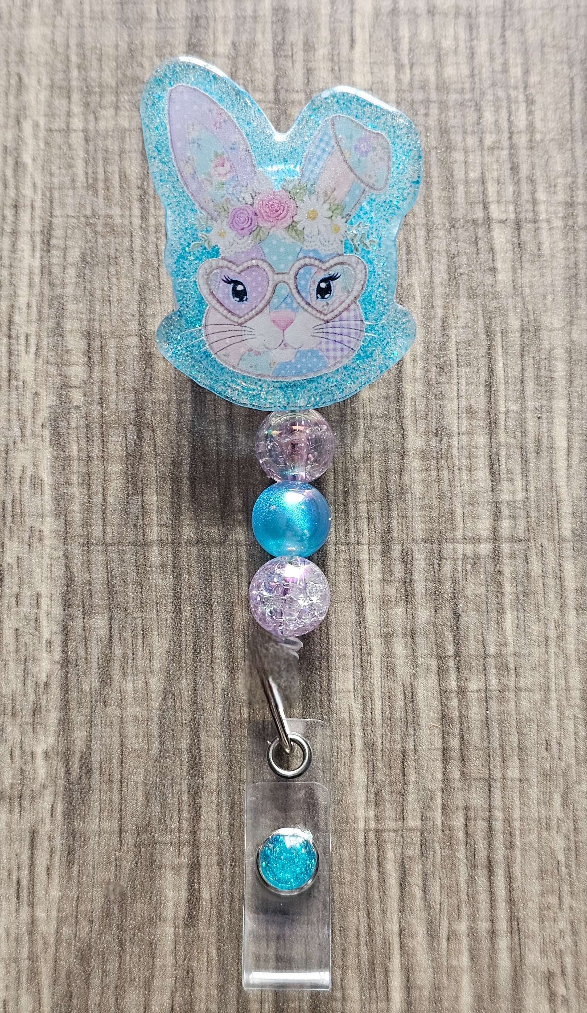 Retractable badge reel featuring a patchwork pattern bunny wearing glasses, a floral crown, and colorful coordinating beads.