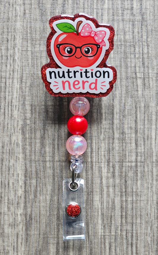 Cute cartoon apple wearing glasses and a bow with the text "nutrition nerd" on a retractable badge reel.