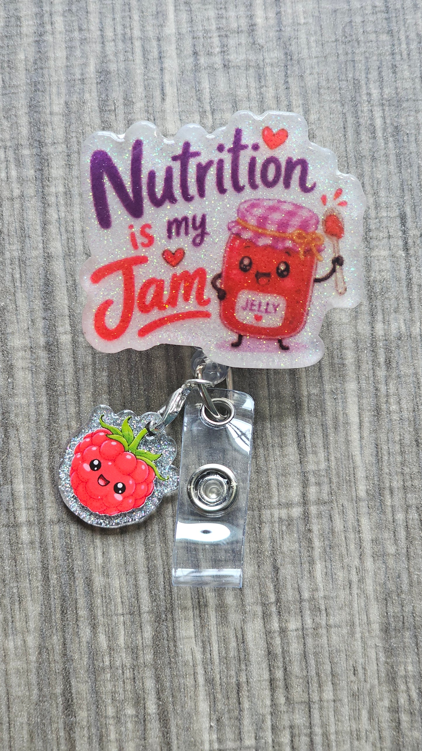 A badge reel featuring a jar of jelly along with the phrase "Nutrition is my Jam " with a joyful joy clip attached