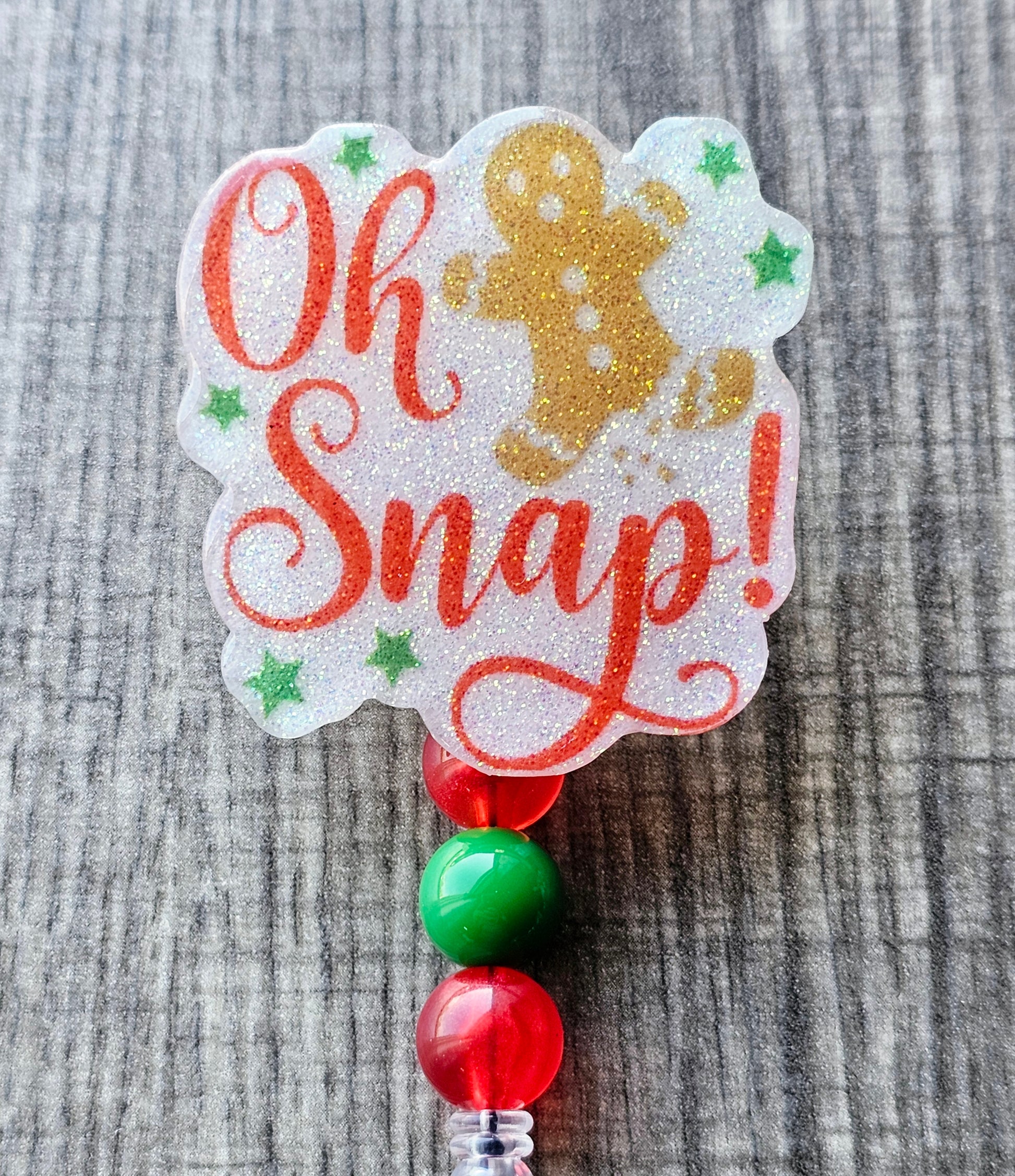 A playful badge reel featuring a gingerbread man with a broken foot and the words "Oh Snap!"