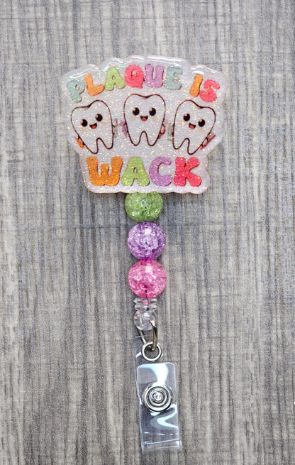 Funny dental badge reel with three happy teeth and Plaque is Wack text.