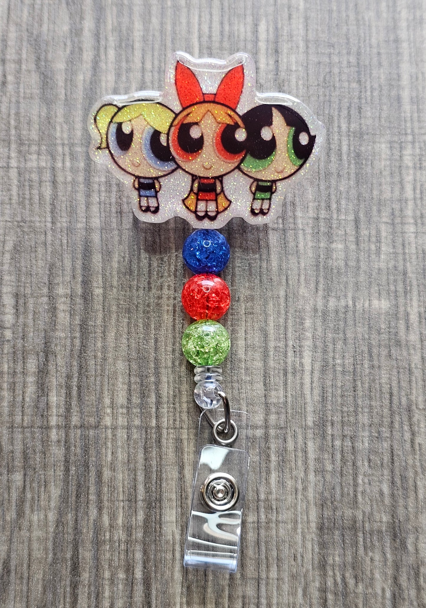 Powerpuff Girls trio badge reel with red, blue, and green beads on a retractable reel.