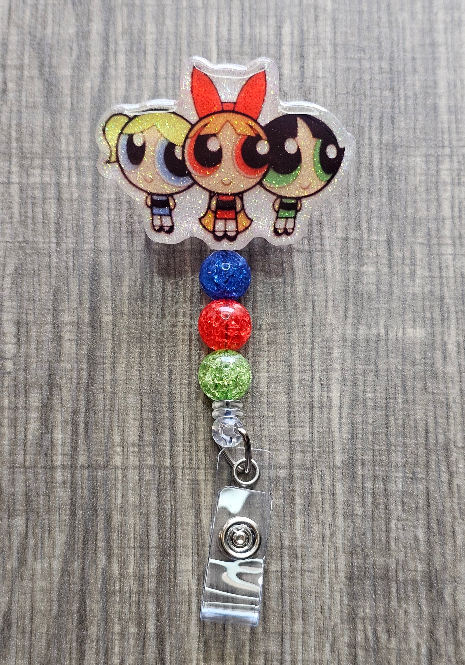 Powerpuff Girls trio badge reel with red, blue, and green beads on a retractable reel.