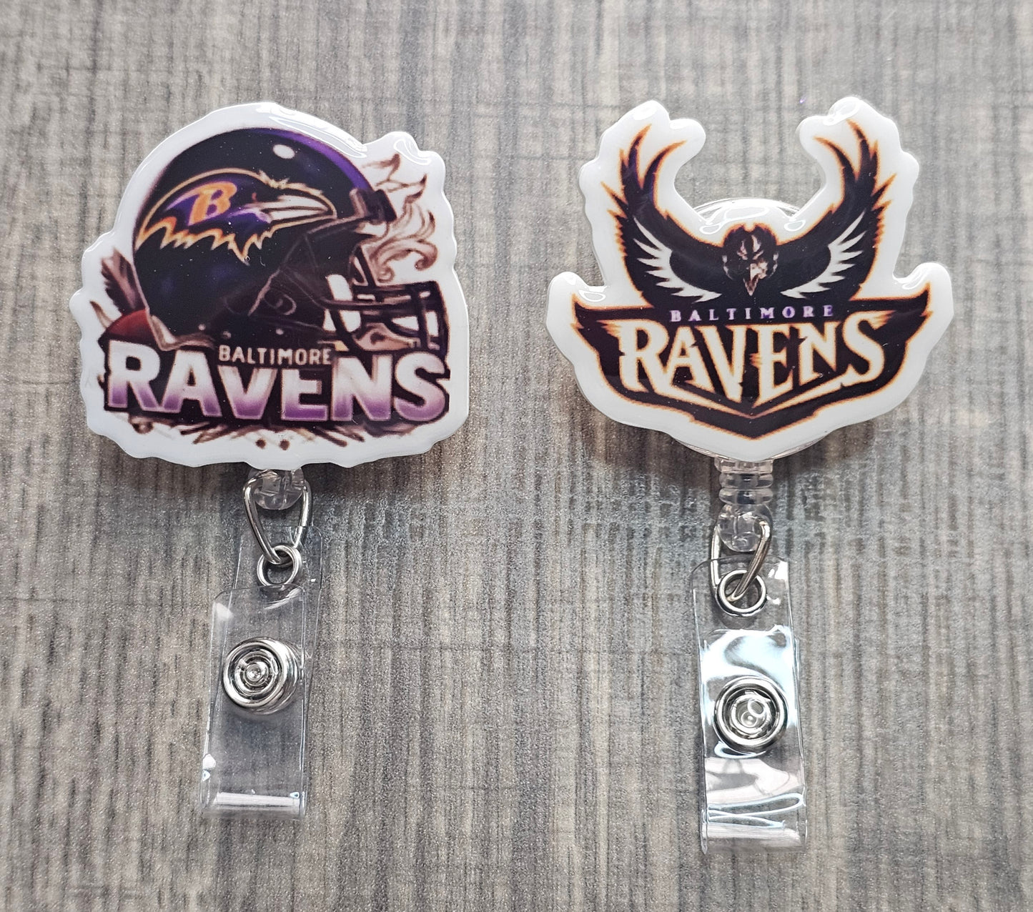 Two Baltimore Ravens badge holders on a textured surface