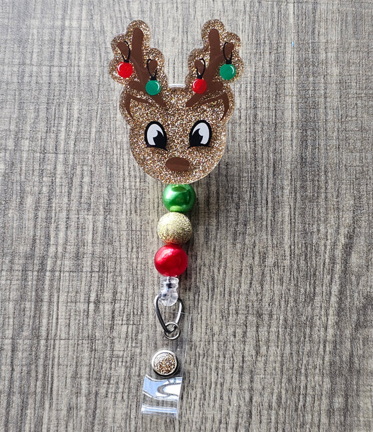 A Badge reel shaped like an adorable reindeer, this badge reel features Christmas decorations hanging from its antlers.