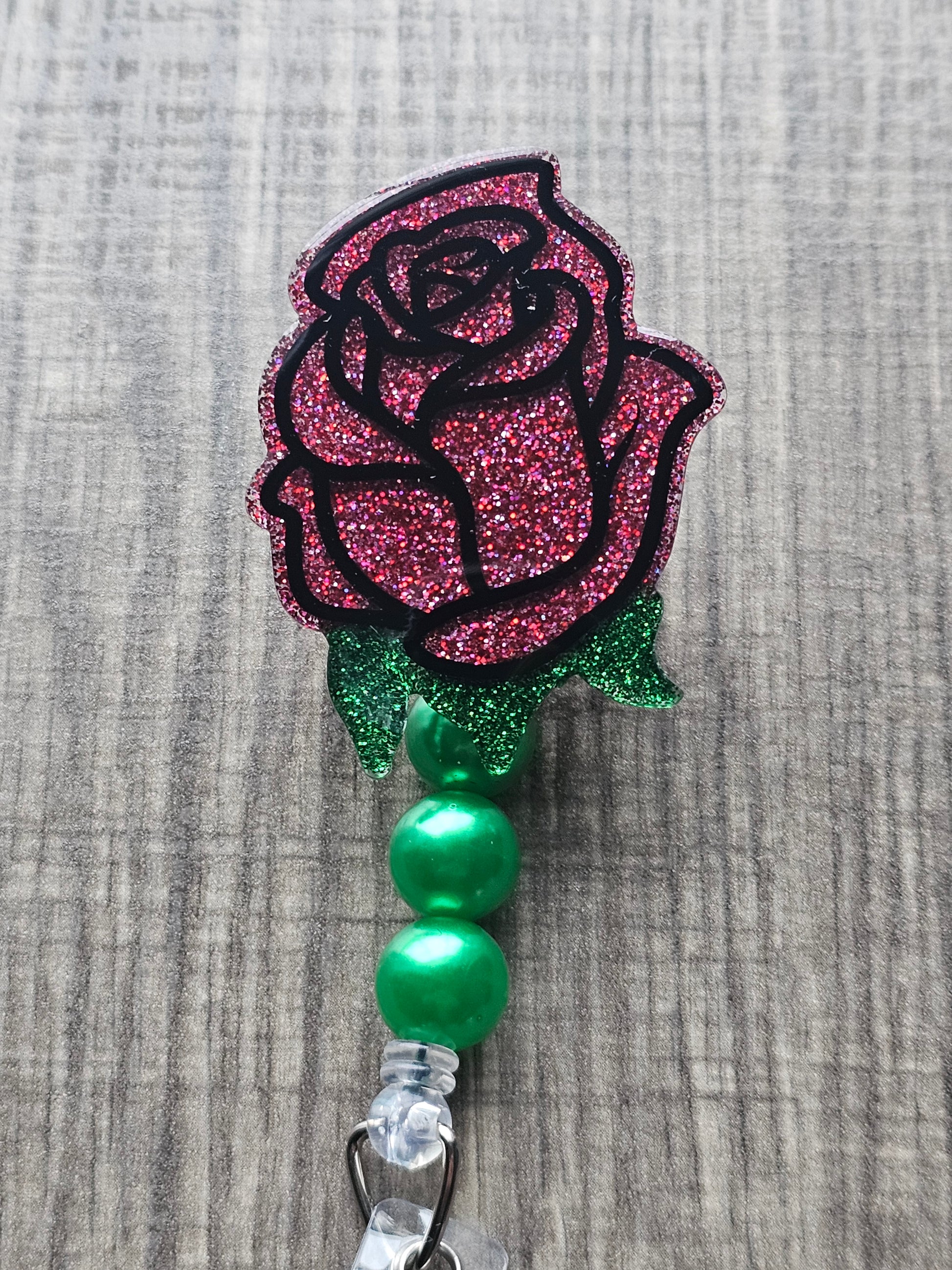 A stunning red rose-shaped badge reel