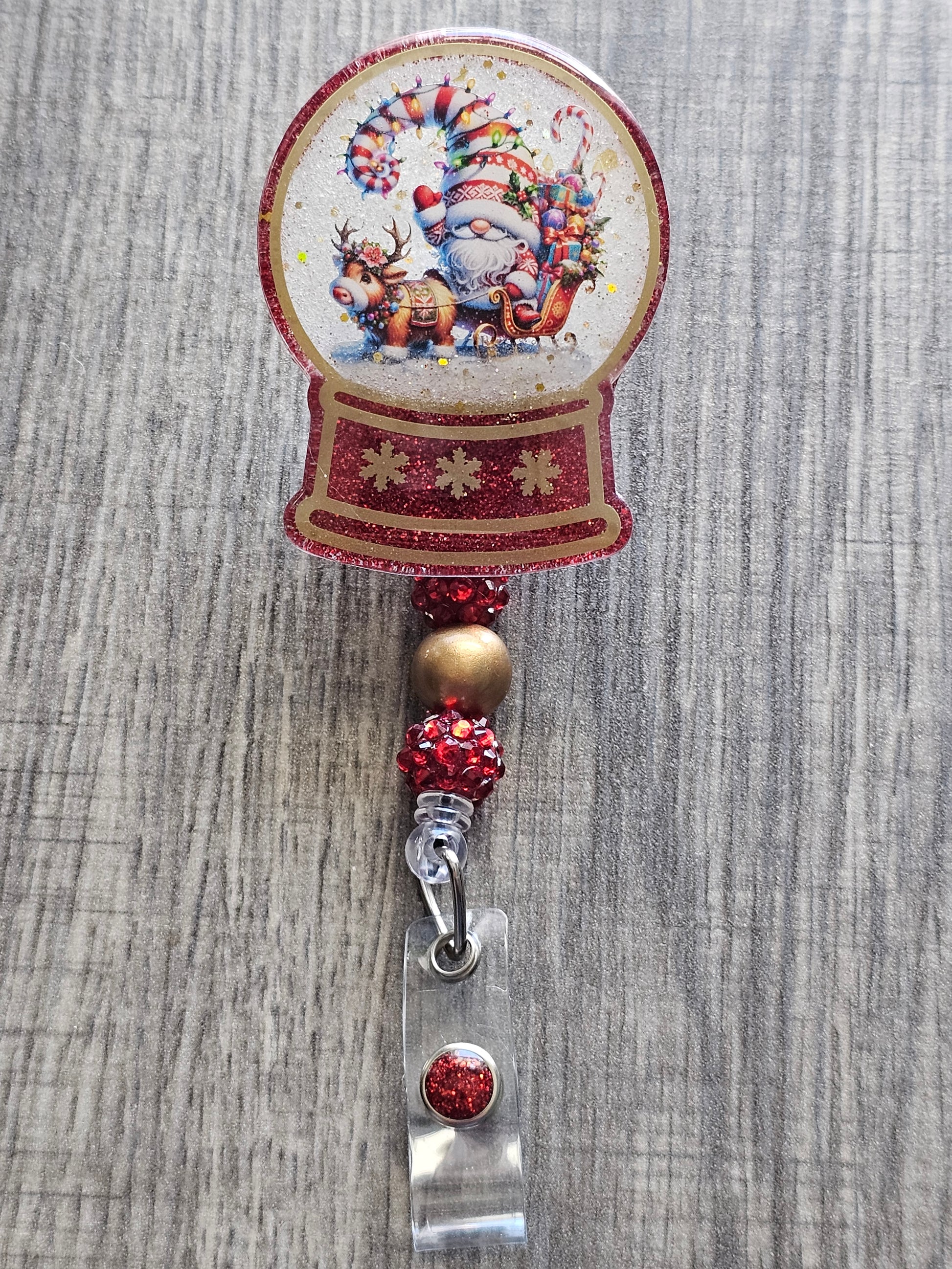 A badge reel with a snow globe design featuring a Santa Gnome with an adorable Reindeer