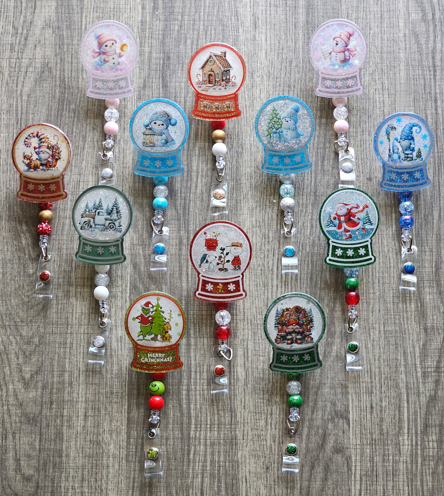 Various Badge Reels in the form of a snow globe featuring various festive designs.