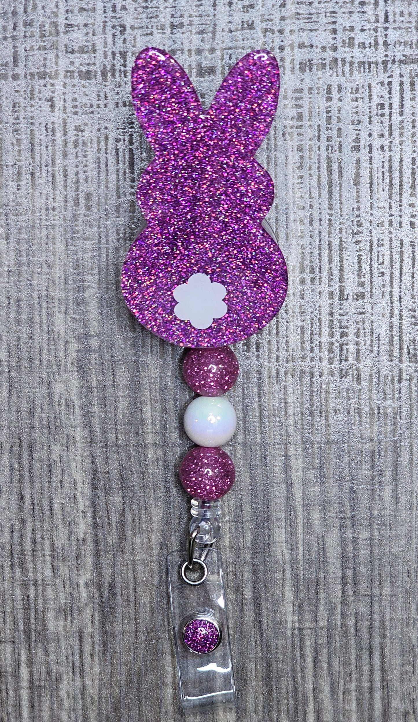 Dark Pink glittery bunny-shaped badge holder on a gray textured background