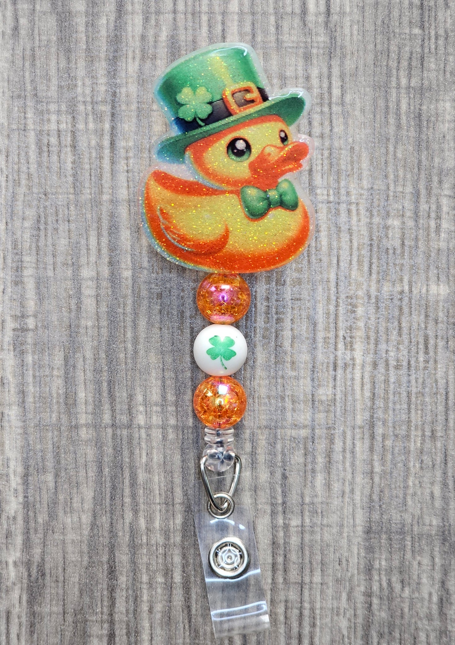 A badge reel featuring an adorable duck wearing a clover hat and bow tie in honor of St. Patrick’s Day.