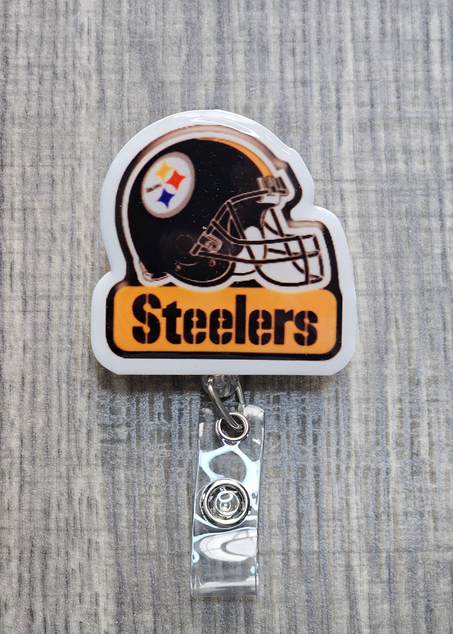  Pittsburgh Steelers helmet and logo with "Steelers" text underneath on a retractable badge reel.