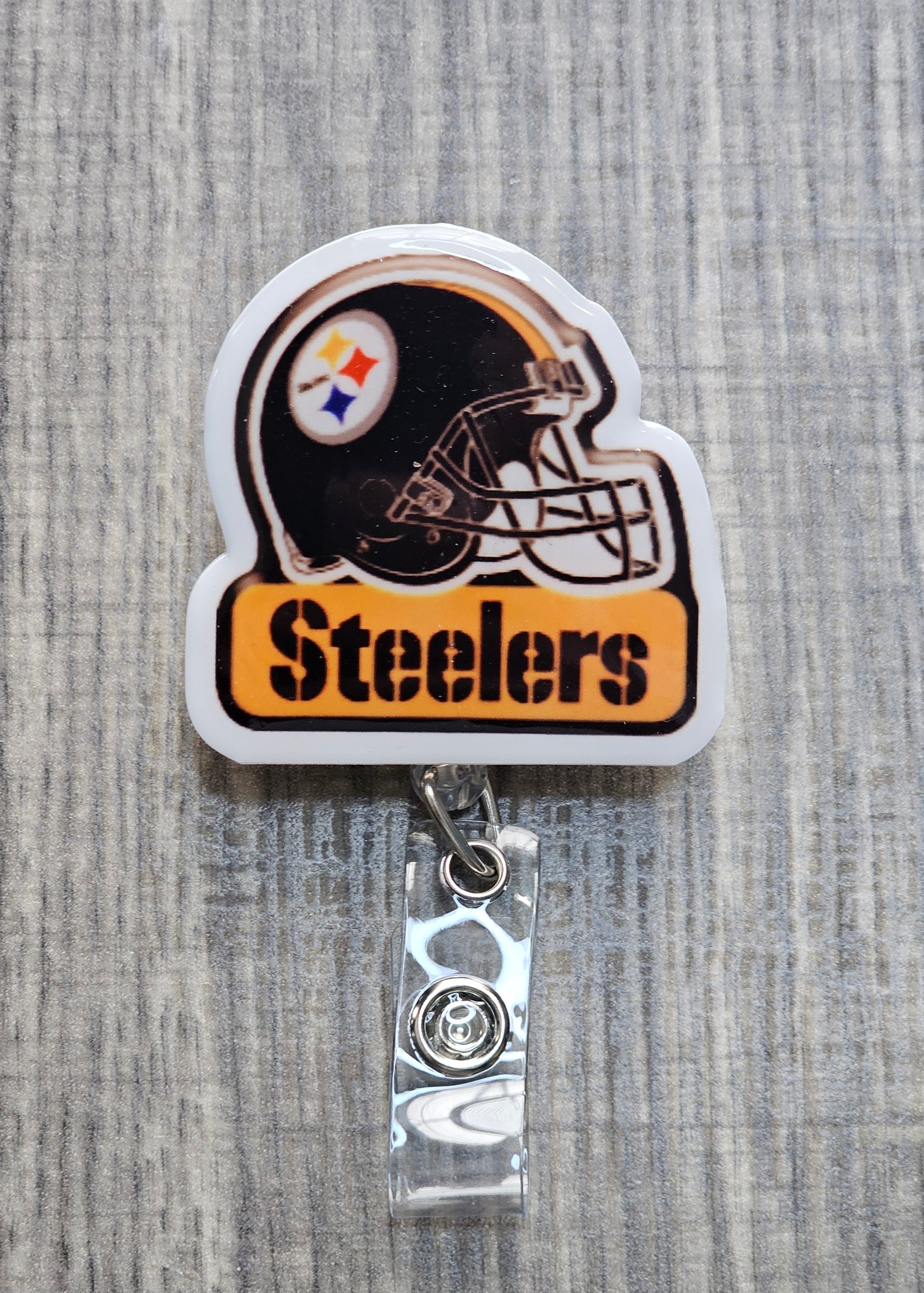  Pittsburgh Steelers helmet and logo with "Steelers" text underneath on a retractable badge reel.