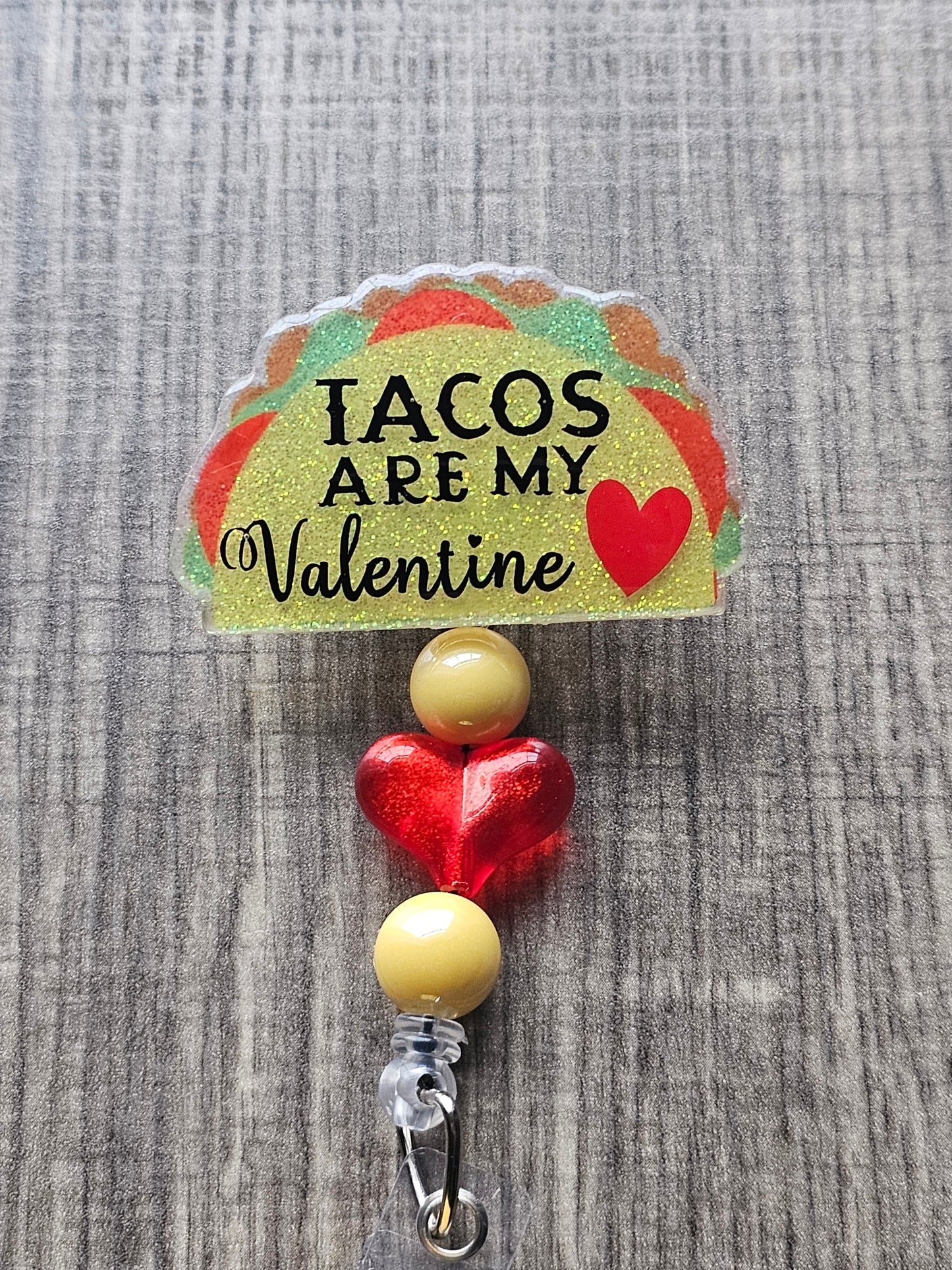 A taco shaped badge reel which states Tacos Are My Valentine with a heart beside it.