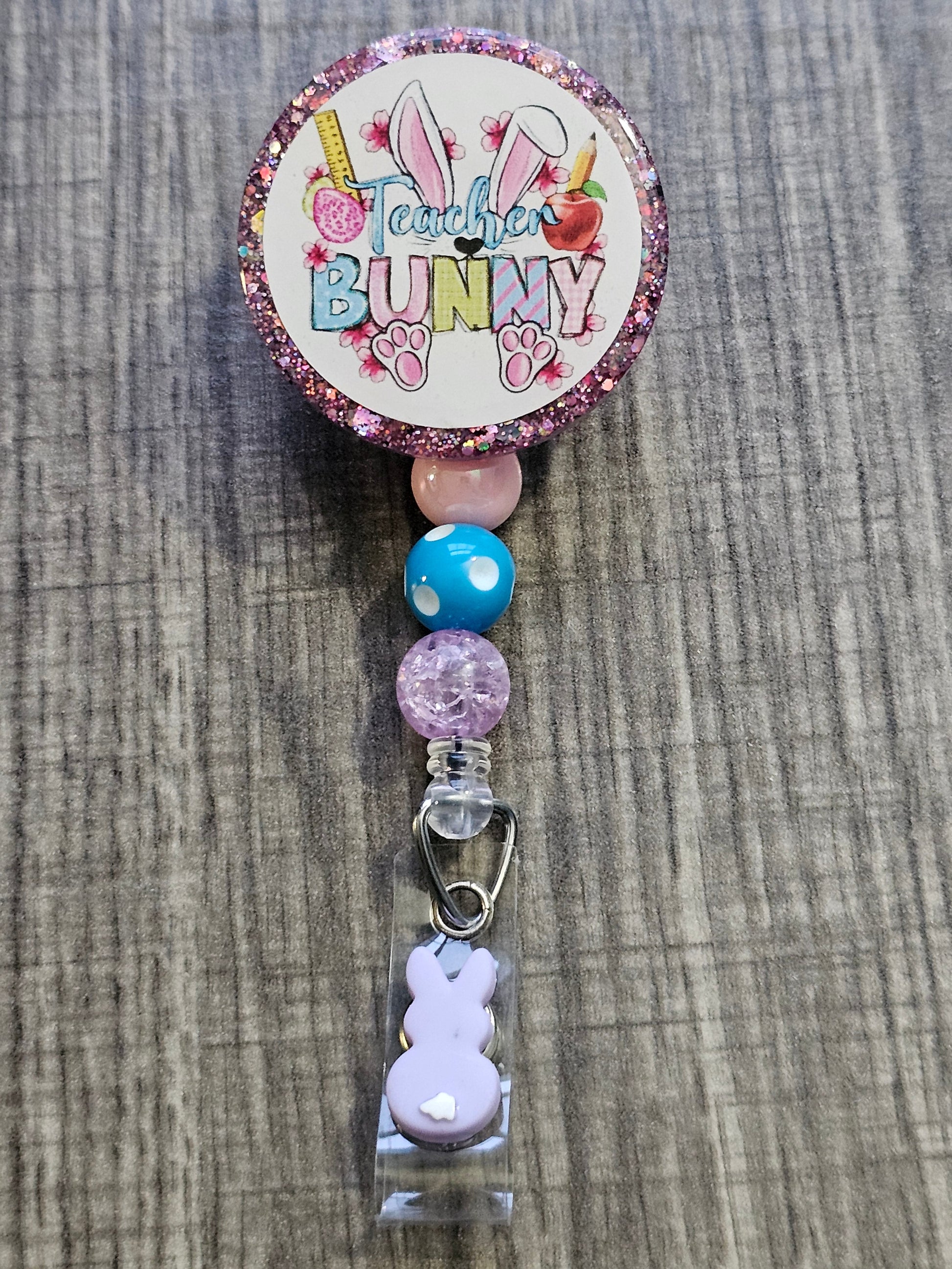  A Badge Reel with the words Teacher Bunny with easter décor.