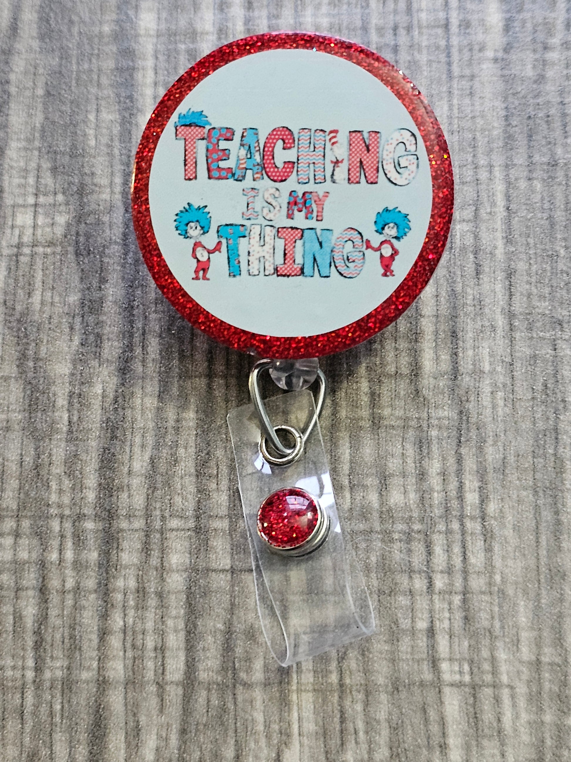 A badge reel with the statement Teaching Is my Thing with a red background 