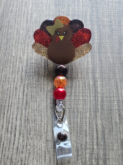 a badge reel featuring a turkey while also being shaped like a turkey 