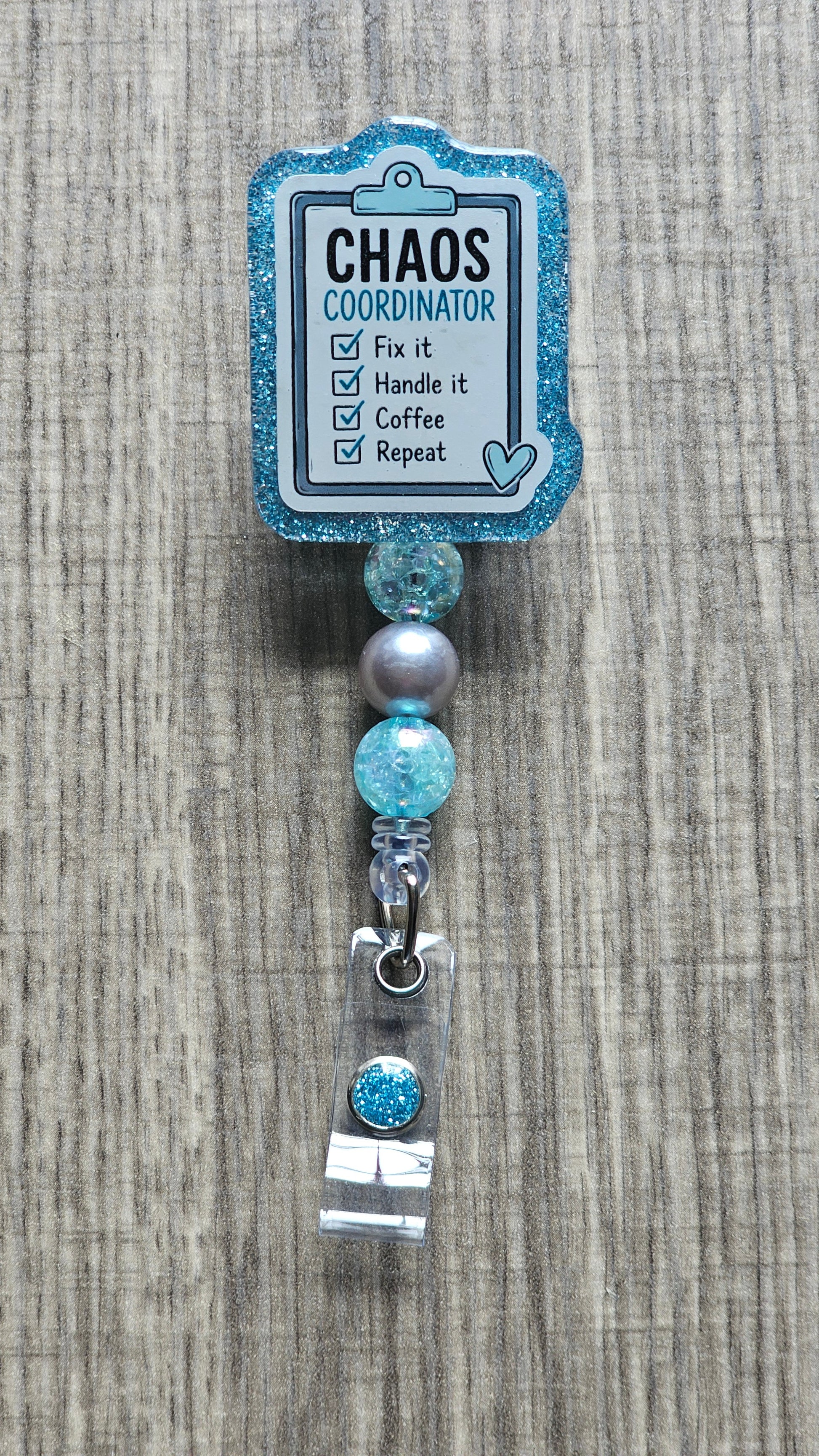 Checklist clipboard with items "Fix it, Handle it, Coffee, Repeat" and text "CHAOS COORDINATOR" for a badge reel.